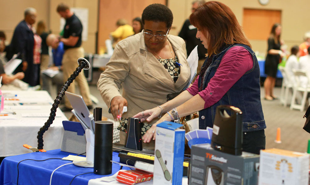 A woman demonstrates assistive technology devices.
